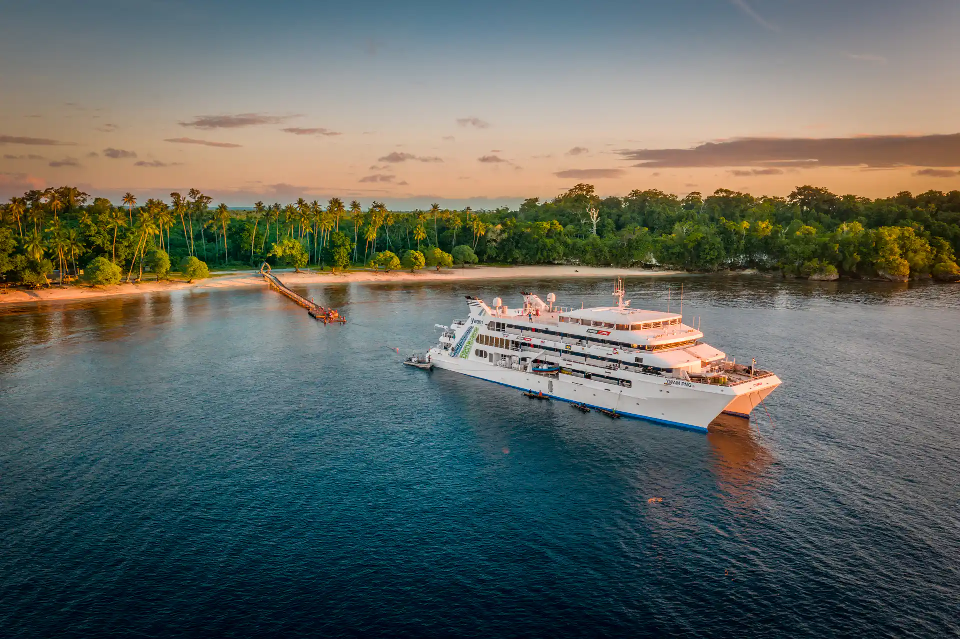 MV YWAM PNG anchored off the coast in Papua New Guinea at sunset